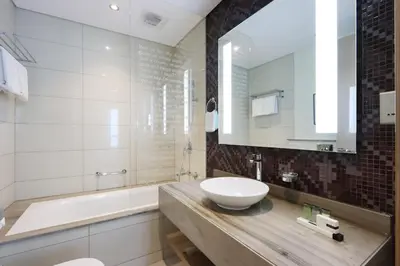 a bathroom with a sink and a tub and a mirror at Stylish 2BR Paramount Apt Near Downtown in Dubai