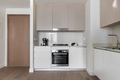 a kitchen with white cabinets and a stove top oven at Waterfront View, Boutique apartment, Lagoon Access in Dubai