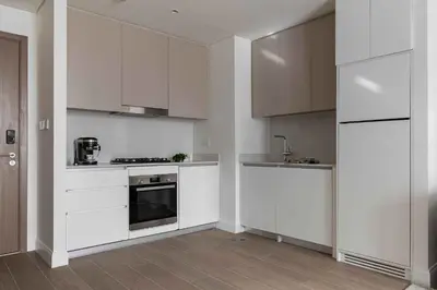 a kitchen with white cabinets and a stove top oven at Waterfront View, Boutique apartment, Lagoon Access in Dubai