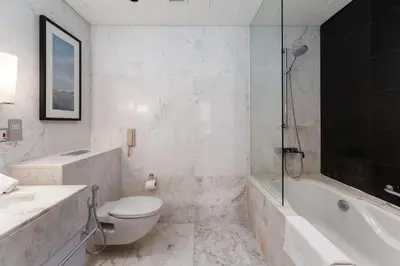 a bathroom with a toilet and a tub and a sink at Panoramic Burj Khalifa Views - Modern & Comfy Gem in Dubai