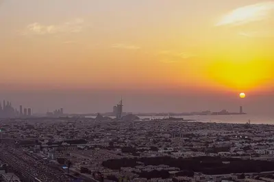 a view of a city with the setting sun at Cozy Sunset Retreat - Burj, Palm & Sea View - 2 BR in Dubai