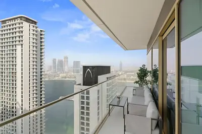 an apartment balcony with a view of the water at Elegant 2BR in Beachfront with Stunning Marina Views in Dubai