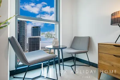 a room with two chairs and a table in front of a window at LUX The Northside Studio in Dubai