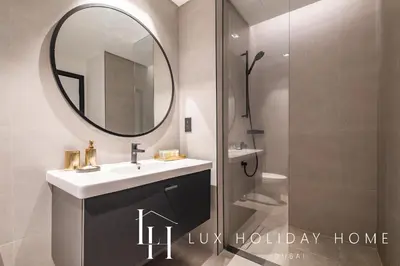 a bathroom with a sink and a mirror and a shower at LUX The Northside Studio in Dubai