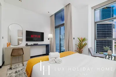 a bedroom with a king sized bed with a tv at LUX The Northside Studio in Dubai