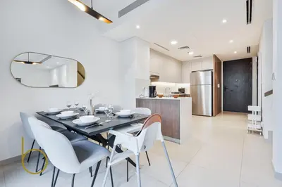 a dining room with a black table and white chairs at Bookable - 4 Bedroom Elan 1 Tilal Al Ghaf Villa in Dubai