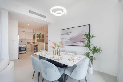 a white dining room with a table and chairs at Luxury 3BR, MaidRoom Full Burj & Fountain Views in Dubai