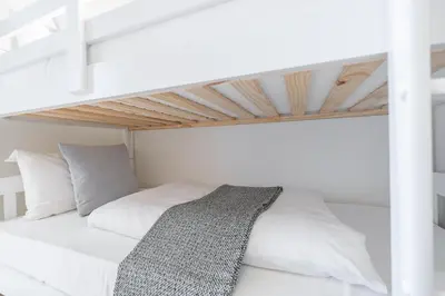 a white bedroom with a loft bed with white pillows at Luxury 3BR, MaidRoom Full Burj & Fountain Views in Dubai