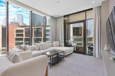 a living room with white furniture and large windows at Lavish 1-Bedroom with Burj Khalifa view in Peninsula in Dubai