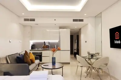 a living room with a couch and a table at Modern Studio Near Dubai Mall Walk to Dubai Canal in Dubai