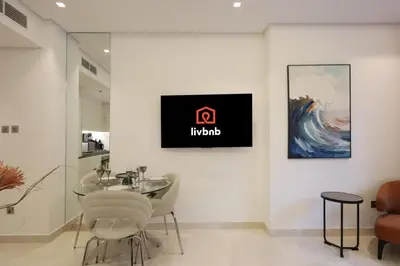 a dining room with a table and a sign on a wall at Modern Studio Near Dubai Mall Walk to Dubai Canal in Dubai