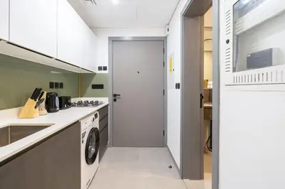 a kitchen with a washer and dryer in it at Modern Home in Sports City with Rooftop Pool in Dubai