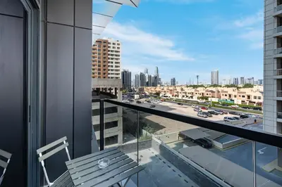 a balcony with a bench and a view of a city at Modern Home in Sports City with Rooftop Pool in Dubai