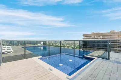 a swimming pool on the balcony of a building at Modern Home in Sports City with Rooftop Pool in Dubai
