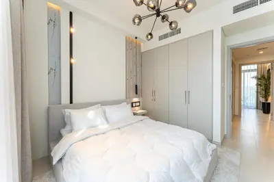 a bedroom with a large white bed and a chandelier at HAVN - Luxurious 4 Bed Villa in Arabian Ranches 3 in Dubai
