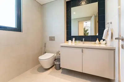 a bathroom with a toilet and a sink and a mirror at HAVN - Luxurious 4 Bed Villa in Arabian Ranches 3 in Dubai