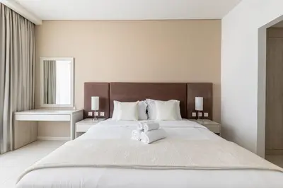 a bedroom with a large bed with a teddy bear on it at Stylish One-Bedroom Oasis - Prime Palm Location in Dubai
