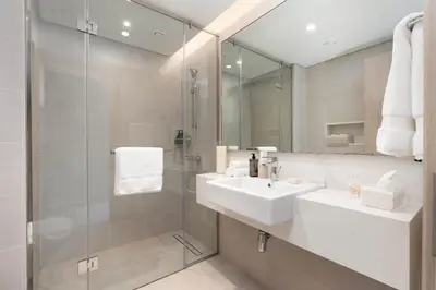 a bathroom with a sink and a glass shower at Luxury 2BR and Study Water View in Al Wasl in Dubai
