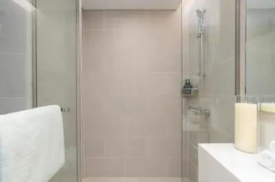 a bathroom with a shower with a glass door at Luxury 2BR and Study Water View in Al Wasl in Dubai