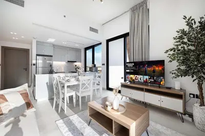 a living room with a kitchen and a dining room at Luxury 2BR with Canal View Burj Khalifa view and Infinity Pool Access in Dubai