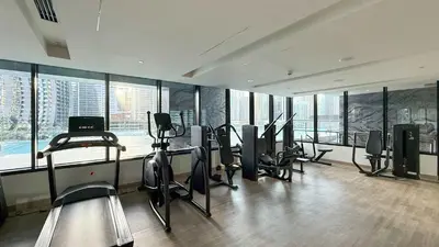 a gym with treadmills and exercise equipment in a building at Luxury 2BR with Canal View Burj Khalifa view and Infinity Pool Access in Dubai