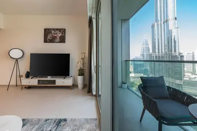 a living room with a tv and a large window at Stunning Burj Khalifa & Fountain Views in Dubai