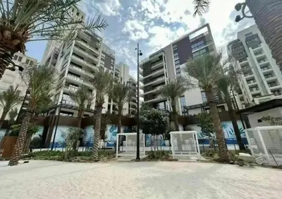 a courtyard with palm trees in front of buildings at DB HOMs in Dubai