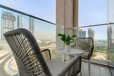 a table and chairs on a balcony with a view of a city at Silkhaus Charming 1BDR in Canal Front Tower in Dubai