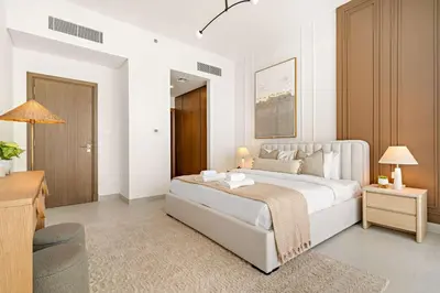a bedroom with a large white bed and a chair at Silkhaus Charming 1BDR in Canal Front Tower in Dubai