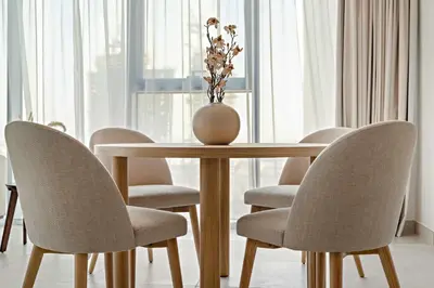 a dining room table with chairs and a vase on it at Silkhaus Charming 1BDR in Canal Front Tower in Dubai