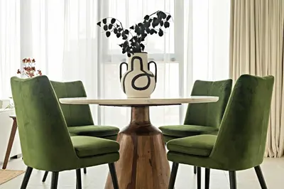 a table with green chairs and a vase with flowers at Silkhaus Luxury 1BDR Stay in Canal Front, Al Wasl in Dubai
