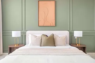 a bedroom with a white bed with two lamps at Silkhaus Cityscape 1BR in Sky Gardens with Metro access in Dubai