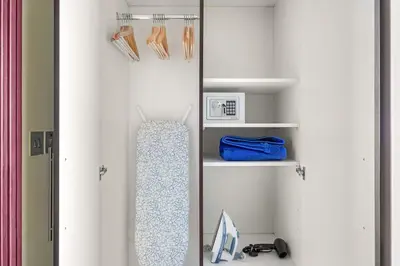 a walk in closet with white walls and shelves at Silkhaus Cityscape 1BR in Sky Gardens with Metro access in Dubai