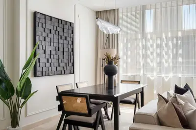 a dining room with a black table and chairs at Silkhaus Elegant 1BDR in Sky gardens with Metro Access in Dubai