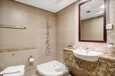 a bathroom with a sink and a toilet and a mirror at Silkhaus Exclusive 1BDR Stay at Sky Gardens in DIFC in Dubai