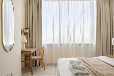 a bedroom with a bed and a desk and a window at Silkhaus Urban 1BDR Escape in Heart of DIFC in Dubai