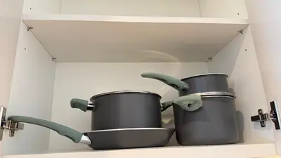 two pots and pans on a shelf in a kitchen at Luxury 2BR Downtown ,5 min walk to Burj Khalifa and Dubai Mall in Dubai