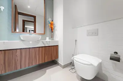 a bathroom with a sink and a toilet and a mirror at 3BR Central Park, Prime Dubai Location in Dubai