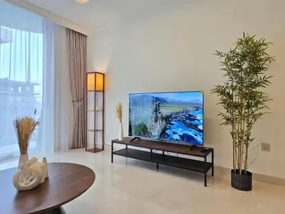 a living room with a flat screen tv on a wall at Brand New 1BR , Fully Furnished in Dubai