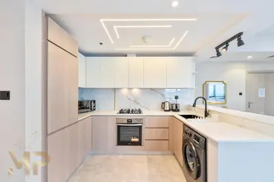 a kitchen with white cabinets and a dishwasher at Marcopolo -Enjoy Marina views from a cozy 1BR in Dubai Marina in Dubai