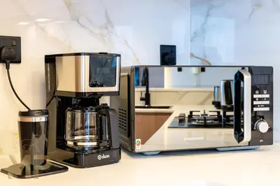 a kitchen with a coffee maker and a microwave at Marcopolo -Enjoy Marina views from a cozy 1BR in Dubai Marina in Dubai