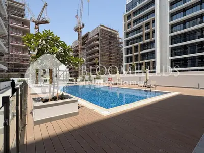 a swimming pool in a city with tall buildings at Bloomfields Deluxe Studio In Azizi Riviera in Dubai