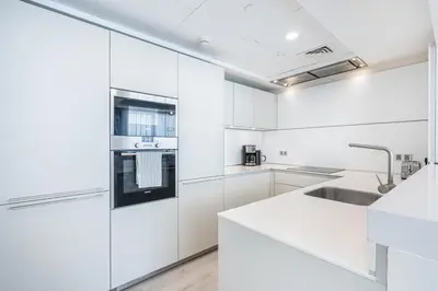 a kitchen with white cabinets and a sink at JBR Home with incredible View & Private Beach in Dubai