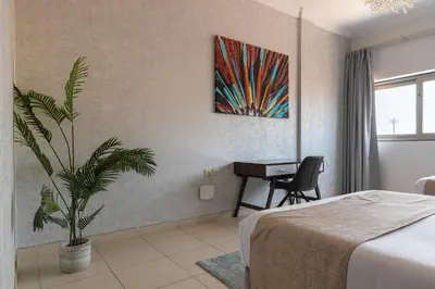 a bedroom with a bed and a desk and a plant at Luxury Beachfront Villa with Private Pool on Palm Jumeirah near Atlantis in Dubai