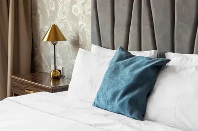 a bed with white and blue pillows and a lamp at Luxury Beachfront Villa with Private Pool on Palm Jumeirah near Atlantis in Dubai