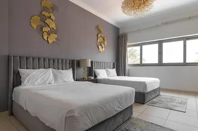 a bedroom with two beds and a chandelier at Luxury Beachfront Villa with Private Pool on Palm Jumeirah near Atlantis in Dubai