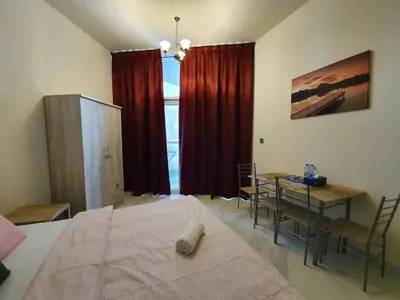 a bedroom with a bed and a table with chairs at Millennium Binghatti Residence - Business Bay - Homeyvillas in Dubai