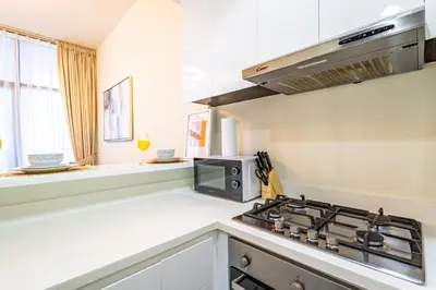 a kitchen with a stove and a microwave at Lovely 1BR Business Bay near Metro - City Skyline Views in Dubai