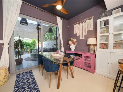 a dining room with a glass table and blue chairs at Family Friendly Villa in Tilal Al Ghaf with Garden and Padel Courts Pet Friendly in Dubai
