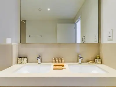 a bathroom with two sinks and a large mirror at TRPS - Downtown Views II Tower 2, Downtown Dubai - 3BR plus Maids - Burj Khalifa View - Walk to Dubai Mall in Dubai
